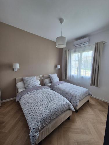a bedroom with two beds and a window at Casa Tío, L'hacienda de Soubran, classé 4 étoiles in Soubran
