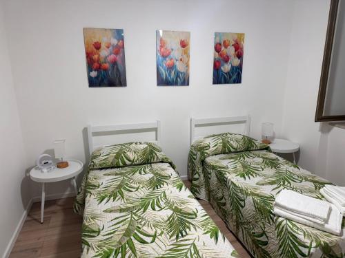 a room with two beds and two paintings on the wall at B&B Fior di Feruci 