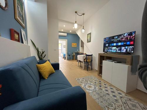 a living room with a blue couch and a tv at Nicuzza in Gela