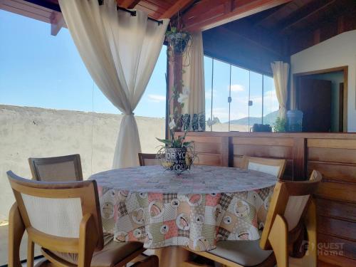 a dining room with a table and chairs and a window at Casa de Madeira Encantadora in Governador Celso Ramos