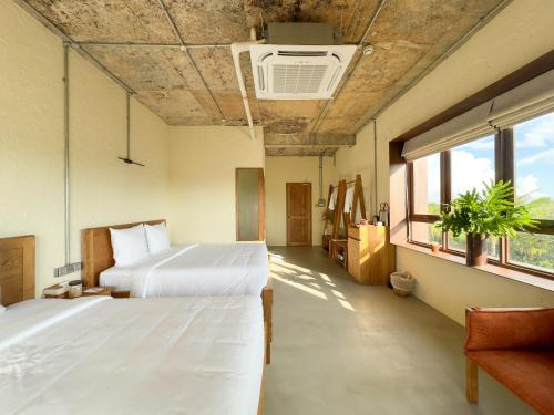 Xóm Chum GăngにあるWoCAL Resort Ke Gaのベッド2台と窓のある病室です。