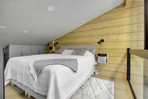 Un dormitorio con una cama grande en una pared de madera. en Deluxe Luosto, en Luosto