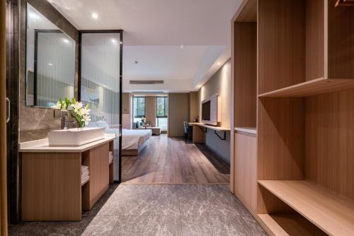 een badkamer met een wastafel en een bed in een kamer bij Shengfeng Mingzuo Hotel in Hangzhou
