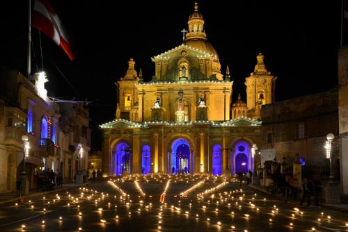 een gebouw met een heleboel kaarsen ervoor bij Nina in Siġġiewi