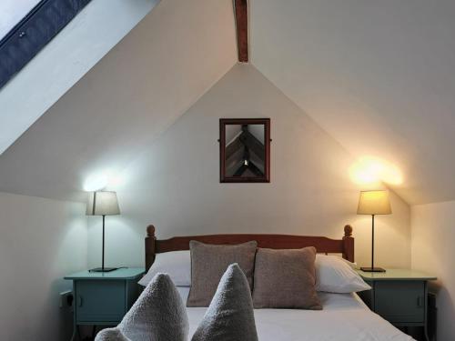 Un dormitorio con una cama con dos mesas y dos lámparas. en White Wing - 29584, en Damerham