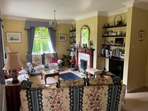 een woonkamer met een bank en een open haard bij Rectory House bed and breakfast in Danby Wiske