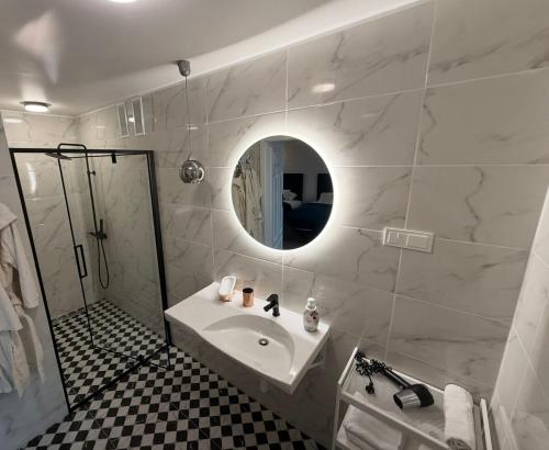 a white bathroom with a sink and a mirror at Rimuošės dvaras in Šniūraičiai