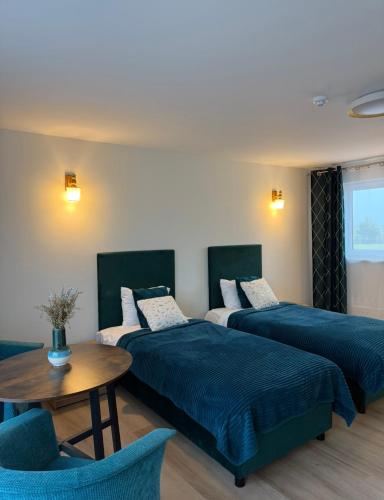 a hotel room with two beds and a table at Rimuošės dvaras in Šniūraičiai