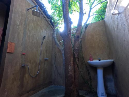Ein Badezimmer mit einem Baum, Dusche und Waschbecken in der Unterkunft Thumbaya Resort Yala in Tissamaharama