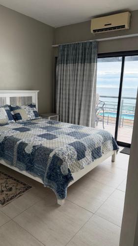 a bedroom with a bed and a view of the ocean at Blue horizon in La Mercy