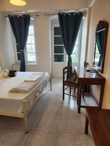 a bedroom with a bed and a table and a desk at Archontiko Hotel in Kalymnos