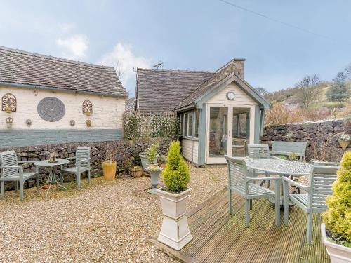 a patio with a table and chairs and a building at The Smithy - E5445 in Brassington