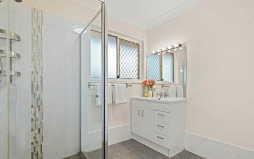 a white bathroom with a sink and a shower at Youth Castle in Brisbane