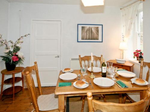 a dining room with a wooden table and chairs at Drum And Monkey Cottage in Chapel en le Frith