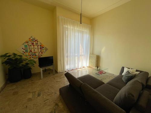 Una sala de estar con un sofá y una ventana. en Residenza Da Vinci, en Imola