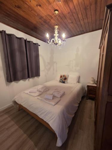 a bedroom with a large bed with a chandelier at Casa Vitorino in Leiria
