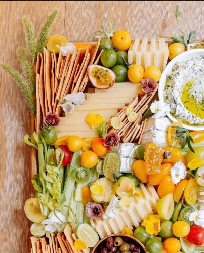 Una bandeja de queso y verduras sobre una mesa de madera. en Le Domaine De Pairis, en Orbey
