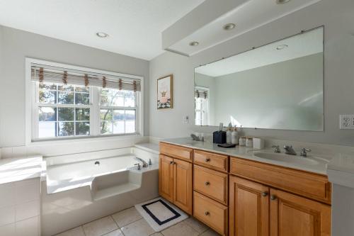 a bathroom with a tub and a sink and a mirror at Dockside Dream – Your Perfect Waterfront Escape in Lexington