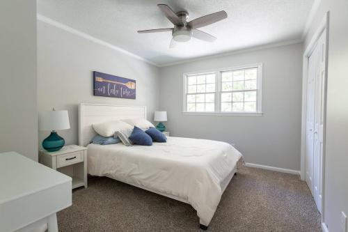 a white bedroom with a bed and a ceiling fan at Dockside Dream – Your Perfect Waterfront Escape in Lexington