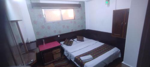 a small bedroom with a bed and a window at Hotel RUMTEK in Gangtok