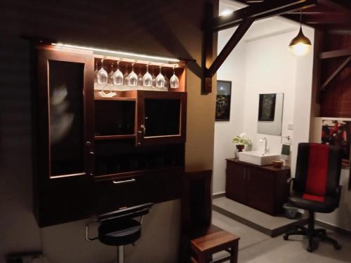 a room with a bar with a chair and a sink at CrossWay Inn Thalawathugoda in Talawatugoda