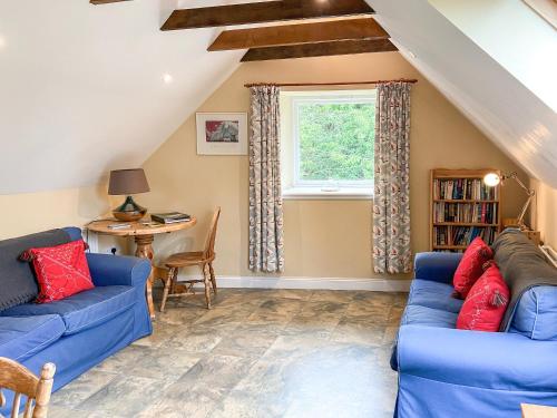 a living room with two blue couches and a window at Fairlaw Garden Cottage in Reston