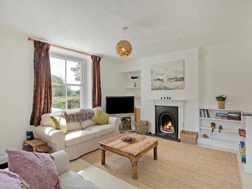 ein Wohnzimmer mit Couch und Kamin in der Unterkunft Duck Cottage in Gargrave