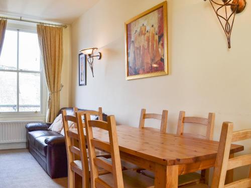 a dining room with a wooden table and a couch at Fell View in Ambleside