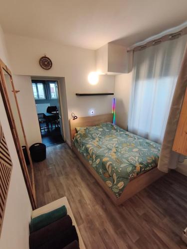 a small bedroom with a bed and a dining room at Agréable appartement "LE COLIBRI" in Châlons-en-Champagne