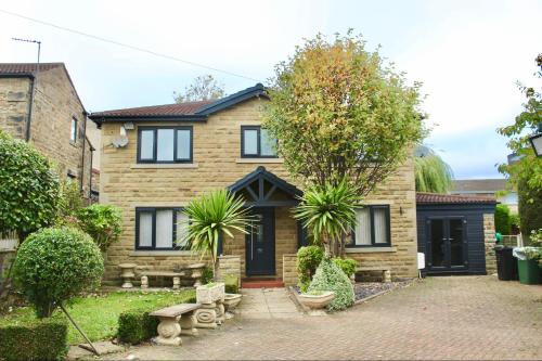 une maison en briques avec une porte noire dans l'établissement Home in West Yorkshire with driveway and 3 double bedrooms - sleeps 6!, à Thornhill