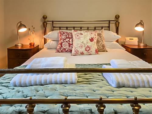 een bed met 2 lampen en kussens erop bij Hollyhock in Tavistock