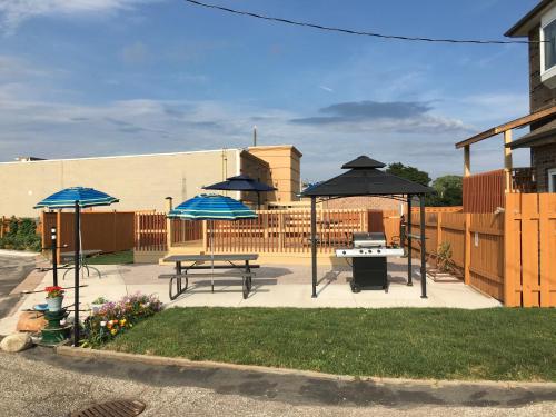 a patio with two picnic tables and umbrellas at Sunparlor Motel in Leamington