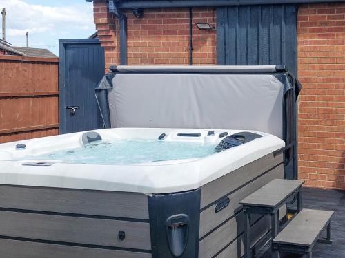 a large bath tub sitting on top of a patio at The Hideaway in Chapel Saint Leonards