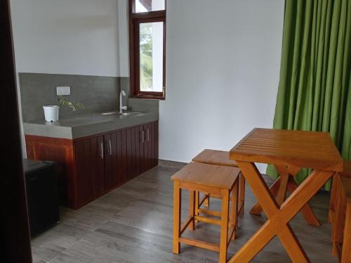 une cuisine avec une table en bois et un évier dans l'établissement Paddi Breeze Cottage - Yala Safari, à Lukasgoda