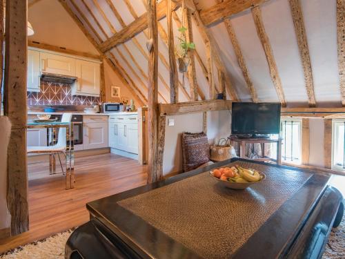a kitchen with a table with a bowl of fruit on it at Woolhouse Barn in Hunton