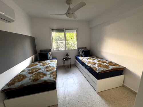 une chambre avec deux lits et une fenêtre dans l'établissement Coral Bay Star - Direct sea location, à Peyia