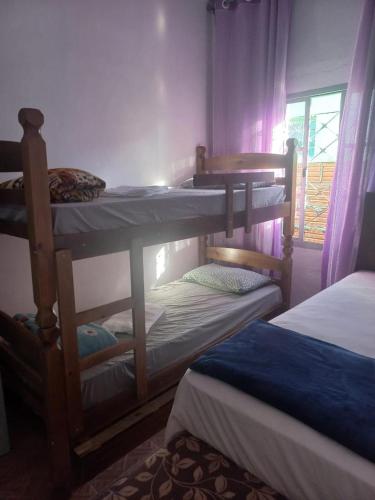 a room with three bunk beds and a window at Casa da Nise in São Gabriel