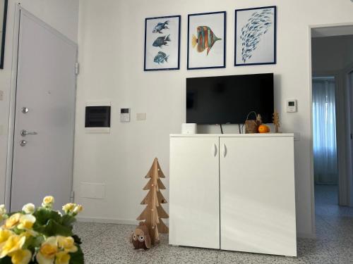 sala de estar con TV y armario blanco en Dimora Azzurra, en Santa Marinella