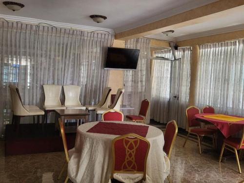 a room with a table and chairs and a television at South gate hotel in Addis Ababa