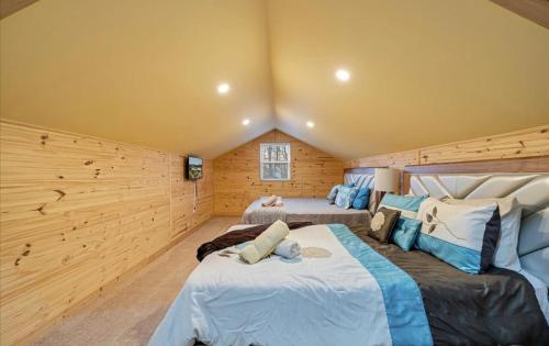 duas camas em um quarto com paredes de madeira em Lake Area 6BR Pet friendly home in Poconos - Your Pocono Retreat em Thornhurst