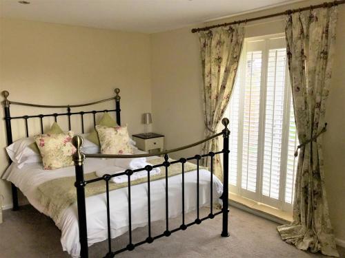 a bedroom with a bed and a window with curtains at Groom's Cottage - E5398 in Dunstall