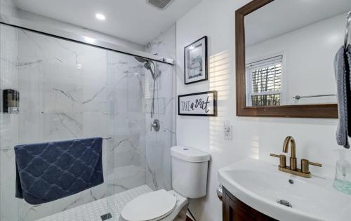 um banheiro com vaso sanitário, pia e chuveiro em Lake Area 6BR Pet friendly home in Poconos - Your Pocono Retreat em Thornhurst