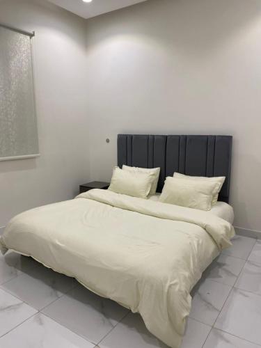 a bedroom with a large bed with white sheets and pillows at شقق المصيف الفندقيه in Hafr Al-Batin