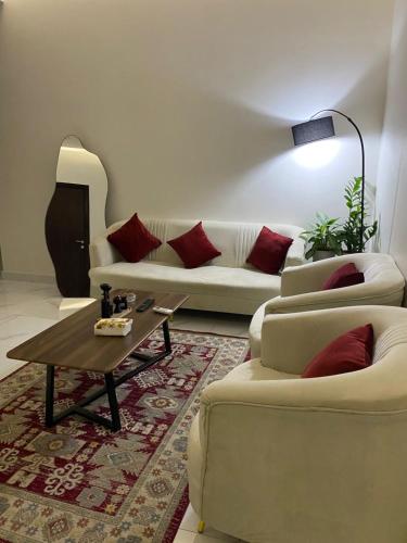 a living room with two couches and a coffee table at شقق المصيف الفندقيه in Hafr Al Baten
