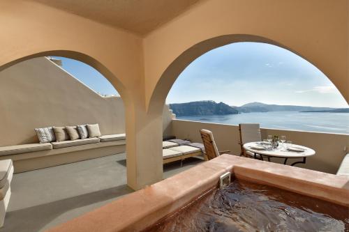 einen Whirlpool in einem Zimmer mit Meerblick in der Unterkunft THE A COLLECTION by K&K in Oia