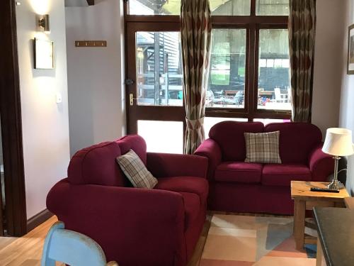 a living room with two purple couches and a window at Heron in Welney