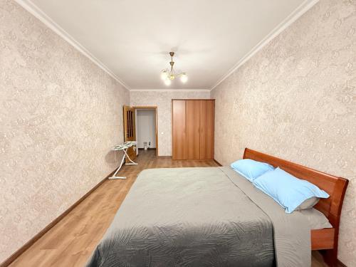 une chambre avec un lit avec des oreillers bleus dessus dans l'établissement Keruen shopping mall, Abu Dhabi Plaza shopping mall, Baiterek, à Astana