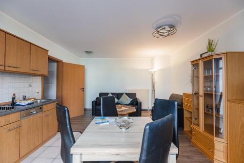a kitchen and living room with a table and chairs at Inselglück App 1 in Norderney
