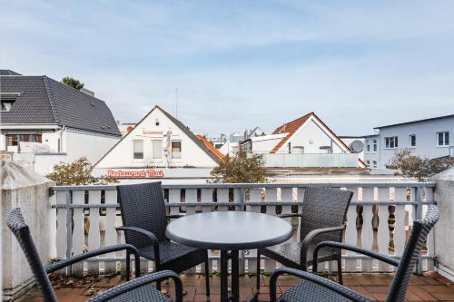 a patio with chairs and a table on a balcony at Inselglück App 1 in Norderney