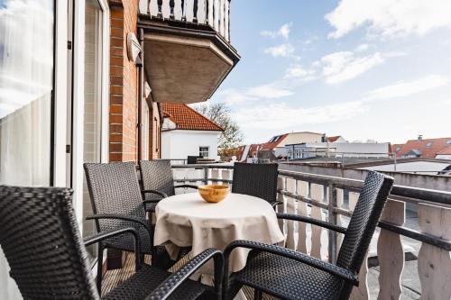 a balcony with chairs and a table with a bowl on it at Inselglück App 2 in Norderney